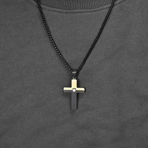 Two-tone black and gold cross necklace with brick texture and center gemstone