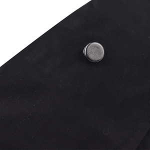 Macro du tissu noir et du bouton en métal gris vintage sur la casquette queue de cheval
