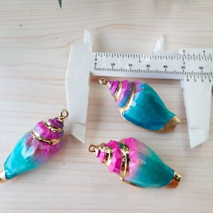 Detaillierte Makroansicht von 40mm Muschelanhängern mit Goldrand und Messschieber für DIY-Schmuck