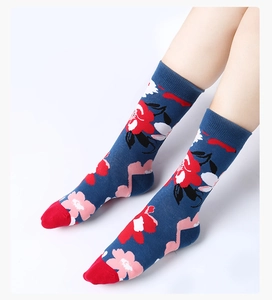 Dettaglio di calze in maglia floreale blu con motivi a fiori rossi e rosa e punta a contrasto