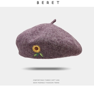 Close-up of sunflower embroidery and wool texture on purple vintage beret