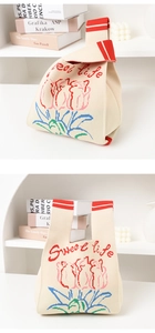 Detail of knitted tote bag with floral patterns and Sweet Life embroidery texture