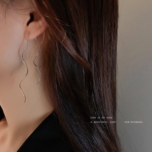 Minimalist silver wave tassel drop earrings shown on model for stylish look