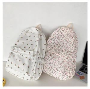 Detail showing two floral canvas backpacks with delicate small flower patterns on white