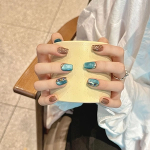 Teal cat-eye and brown glitter coffin press-on nails with silver line and rhinestone accents