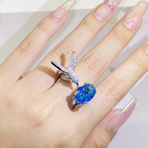 Detailed close-up of hummingbird ring featuring sparkling pavé crystals and a blue gemstone