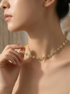 Détail du collier à fleurs dorées avec centres bleus et finition raffinée en or 18 carats
