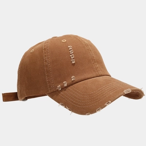 Detail of distressed dark camel baseball cap with frayed brim and vintage worn texture