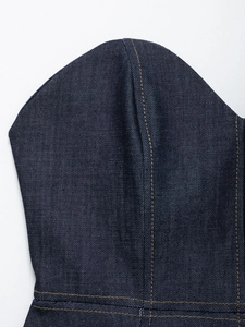 Detailed view of dark blue denim corset top with contrasting orange stitching and seams