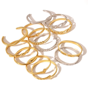 Mix of gold and silver stainless steel bangles featuring twist and geometric heart designs