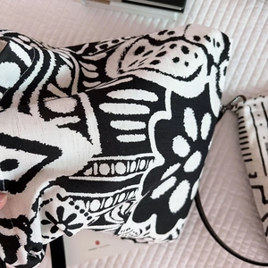 Close-up of bohemian black and white abstract floral patterns on textured linen tote bag