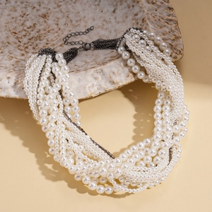 Elegant multi-layered pearl necklace with rhinestone accents on a ceramic display