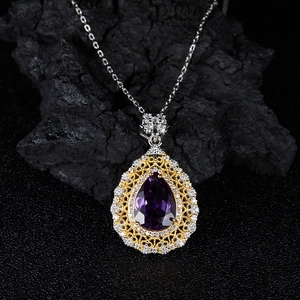Macro shot of purple teardrop gemstone pendant with gold filigree and diamond accents