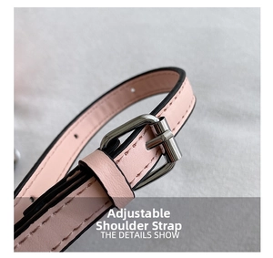 Detail of adjustable pink leather shoulder strap with silver buckle and black oil edges