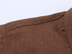 Close-up of the brown textured faux-linen fabric with detailed stitching on the V-neck dress