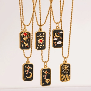 Detail of vintage tarot pendants with sun and moon motifs in gold and black enamel