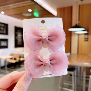Set mit zwei rosa Mesh-Haarspangen für Mädchen auf einer weißen Displaykarte in weichem Licht