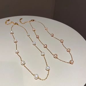 Detail of white and pink freshwater pearls on gold plated necklaces with lobster clasps