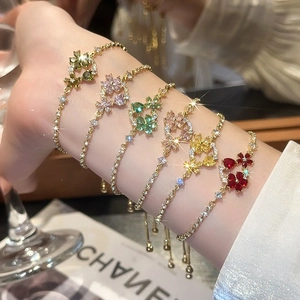 Detailed close-up of five 18k gold-plated flower bracelets with colorful gemstones