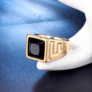 Detail of vintage gold ring with black square stone on a white ceramic hand model