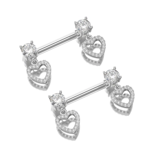 Dettaglio di piercing per capezzoli in argento con pendenti a cuore in zirconi lucidi