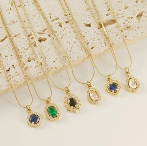 Detailed macro view of six gold-plated necklaces with colorful zirconia gemstone pendants