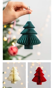 Detail of hanging honeycomb paper Christmas tree ornaments in green, cream, and red colors