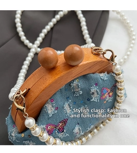 Detailed macro view of denim kiss-lock bag with wood frame and colorful butterfly embroidery