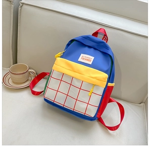 Detail view of colorful canvas kids backpack with red plaid front pocket and zipper closure