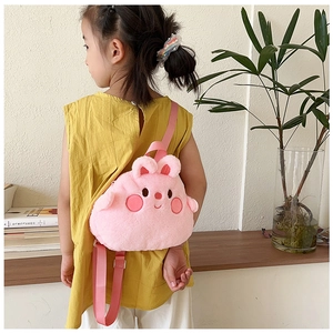 Rear view of a young girl wearing a cute pink plush cartoon backpack with 3D ears
