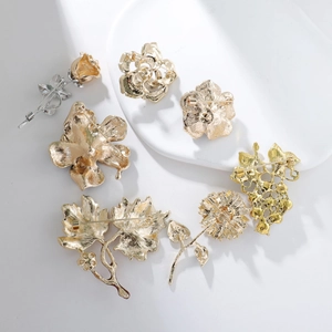 Detail view of the back of gold alloy brooches showing secure pin clasps and craftsmanship