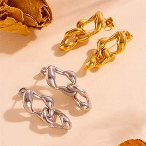 Goldene und silberne Quasten-Blatt-Ohrringe aus Edelstahl auf rustikalem Hintergrund