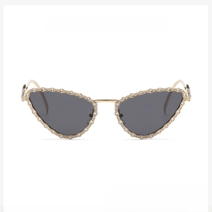 Detailed view of cat eye sunglasses with gold frame, black lenses and rhinestone edges