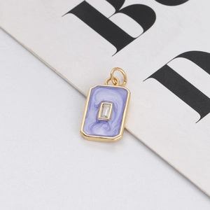 Detailed close-up of a golden rectangular pendant with purple marble enamel and zircon