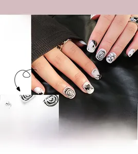 Close-up of black and white graffiti press-on nails with modern art face line patterns