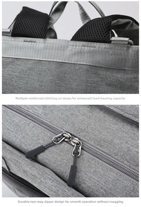 Detail of reinforced stitching on straps and dual metal zippers of the gray diaper bag
