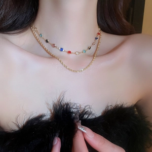 Close-up of double-layer gold necklace with colorful zircon stones on female neck