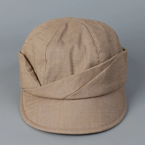 Macro view of textured linen fabric with layered crossover design on brown newsboy cap