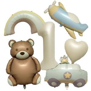 Flat lay of vintage matte birthday balloons including teddy bear, number 1 and rainbow shapes