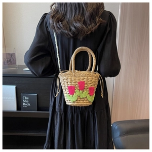Detailansicht der Stroh-Eimertasche mit Tulpenstickerei und Perlenketten-Schultergurt