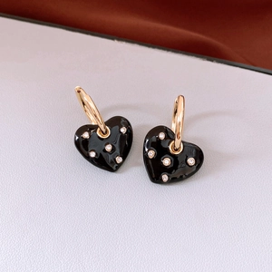 Detail of black heart drop earrings with gold hoops and sparkling rhinestone accents