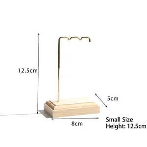 Small jewelry stand with golden metal rack and light wood base measuring 12.5cm in height