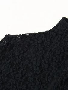 Detailed macro view of black lace fabric with intricate floral patterns and mesh texture