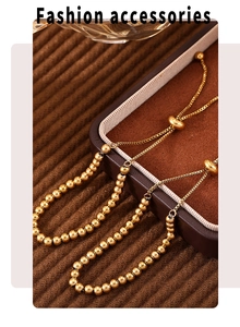 Detail of 4mm gold beaded bracelets on brown velvet display with adjustable sliders