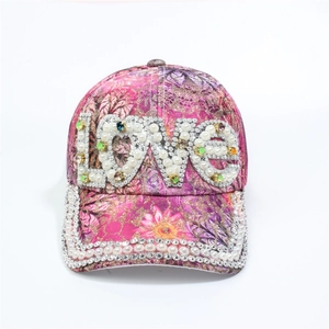 Close-up of LOVE letter motif with pearls and rhinestones on floral baseball cap