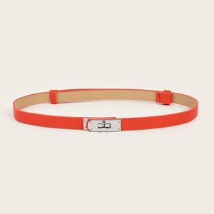 Detail of orange cross-grain leather belt featuring a sleek silver metal turn-lock buckle