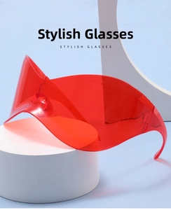 Detail view of red translucent wrap-around Y2K sunglasses on a minimalist white platform