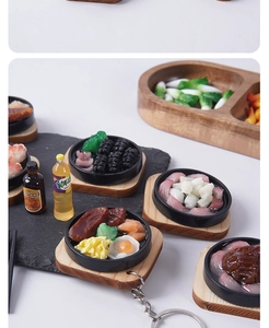Detailed close-up of miniature teppanyaki food keychains with steak and resin drinks