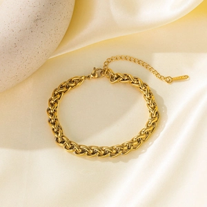 18K gold plated stainless steel braided chain bracelet on beige silk background