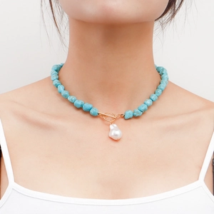 Detail of irregular blue turquoise beads and large baroque pearl pendant with gold OT clasp